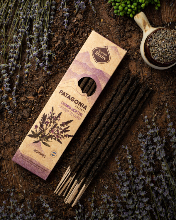 En la imagen se ve el sahumerio patagonia anti estrés, con varillas de color oscuro. A su alrededor hay muchas flores de lavanda