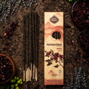Una foto del Sahumerio Patagonia Seductor, con sus varillas oscuras con flores de hibisco. Rodeado de flores de lavanda y plantas verdes